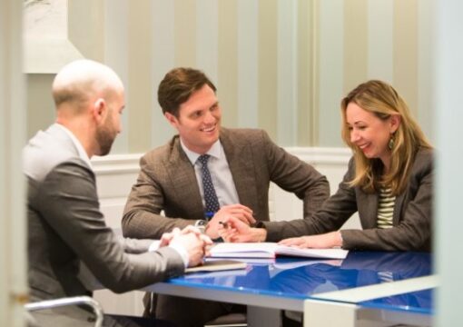 Business people smiling with a client around a table