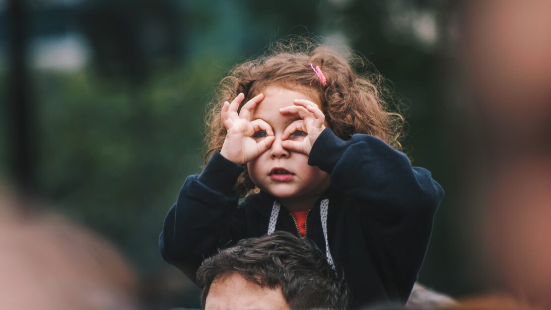 Small girl on her Dad's shoulders